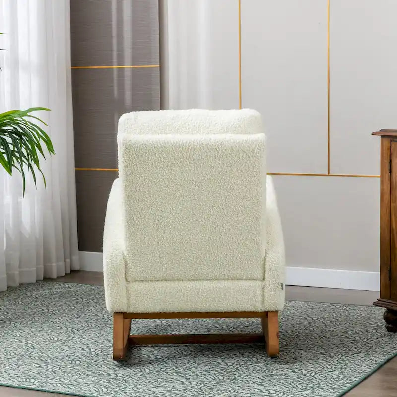 Fauteuil à bascule haut dossier en tissu Teddy crème, base en bois massif, poche latérale