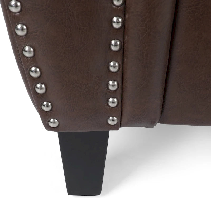 Fauteuil club en similicuir marron cognac avec cloutage et accoudoirs roulés